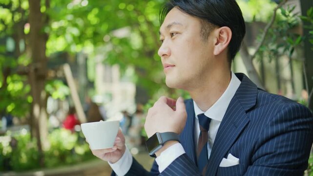 Japanese businessman with coffee lost in thought at a cafe