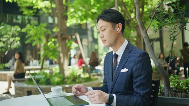 Businessman gesturing during a video call at an outdoor cafe