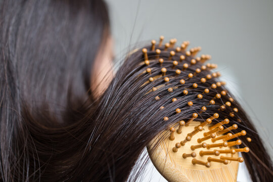 Wooden brush bristles in thick dark hair