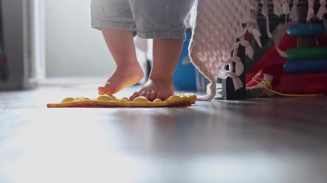 Toddler standing on a textured orthopedic mat for sensory development and foot health at home