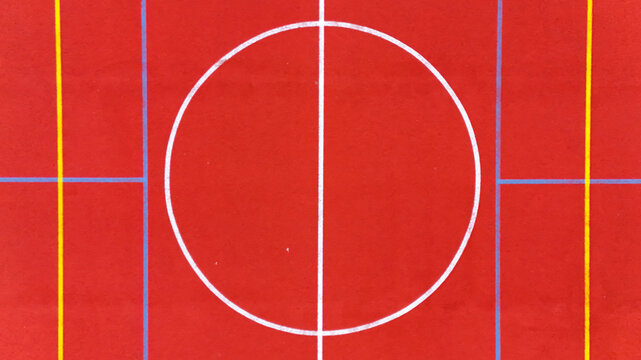 Aerial view of a vibrant red sports court with white and yellow markings in Riga, Latvia.