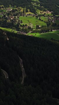 Cortina d&rsquo;Ampezzo, Province of Belluno, Veneto, Italy - A Tranquil Alpine Valley Surrounded by Lush Forests, Green Fields, and Scenic Mountain Villages in the Dolomites - Vertical Shot