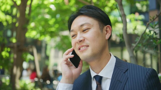 Businessman having a cheerful phone conversation at a cafe