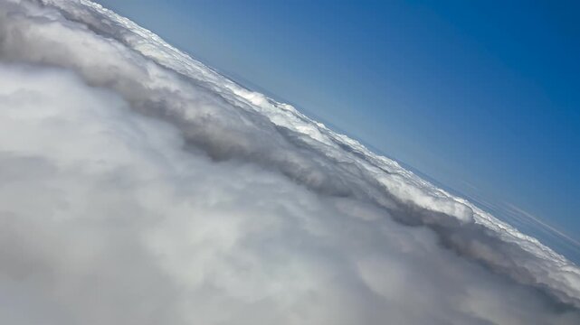Immersive fighter jet view from the cockpit of a jet flying over and entering into a layer of stratus clouds while doing an abrupt left turn at high G-force. 4K shot.