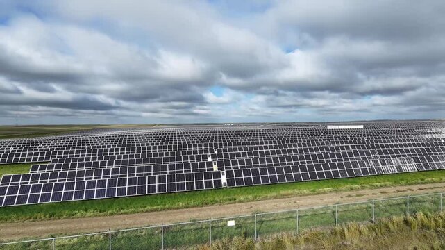 Aerial approach to solar panels at large solar farm near Jenner, Alberta, Canada