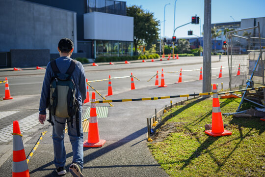 Man walking along the traffic cones on pedestrian walkway. Auckland.