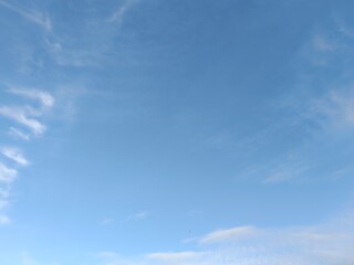 Obraz premium Bright blue sky with thin white clouds. Natural daytime background with copy space