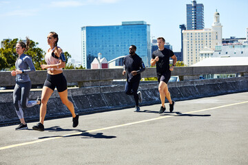 Fototapeta premium Running, people and fitness in city with cardio, wellness and endurance training for marathon. Runner, group or club with exercise for race preparation, sports activity and health in urban town