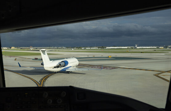 View of a private jet taxiing on the tarmac at an airport under a cloudy sky in Chicago, Illinois, United States.