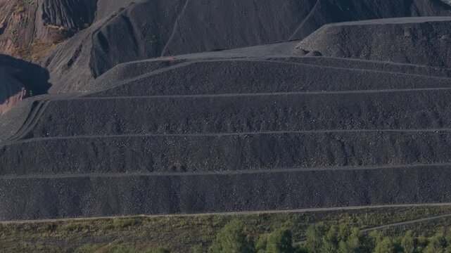 Heavy machinery working on a terraced slag heap in a coal mining area