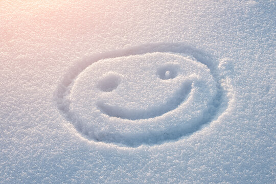 Happy smiley face drawn on fresh snow in a winter landscape