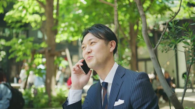 Businessman smiling during a phone call at an outdoor cafe