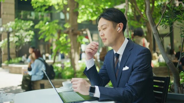 Japanese businessman in an online meeting with wireless earphones
