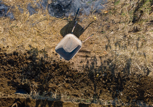 Aerial View of a Traditional Farm Cart in an After-Harvest Rice Field with Rice Straw Ash. The Rural Agricultural Scene Highlights Post-Harvest Farming Practices and Field Management Viewed from Above