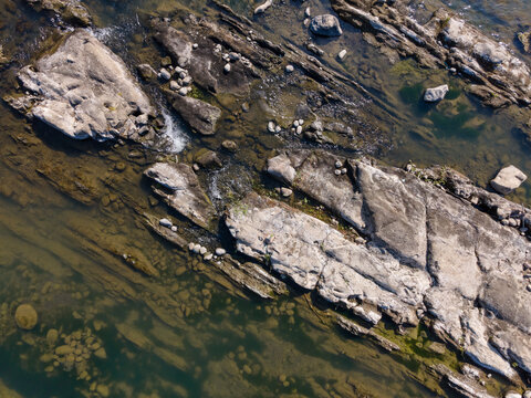 Aerial View of Rugged Rock Formations in a Clear Turquoise River During Morning in Wangon, Central Java, Indonesia. Natural Rocky Features and Pristine Water River Landscape Viewed from Above.