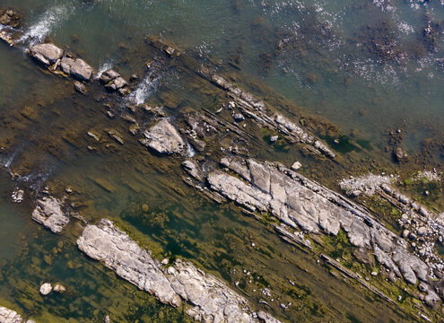Aerial View of Rugged Rock Formations in a Clear Turquoise River During Morning in Wangon, Central Java, Indonesia. Natural Rocky Features and Pristine Water River Landscape Viewed from Above.