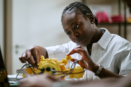 African American young woman engineer assembling robotics prototype in laboratory. Visual represents STEM education, technology innovation for engineering campaign