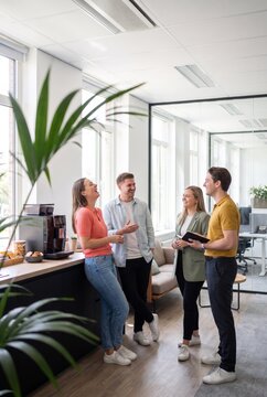 Coworkers laughing together at the office coffee counter