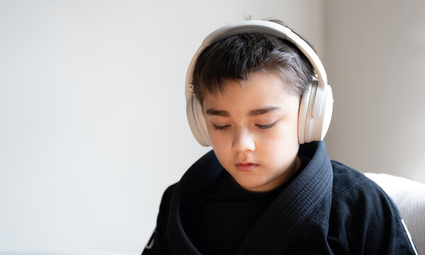 Education concept, Child wearing headphones listening to audio at home with calm focus and copy space, concept of digital learning, online education, music, technology and modern childhood lifestyle.