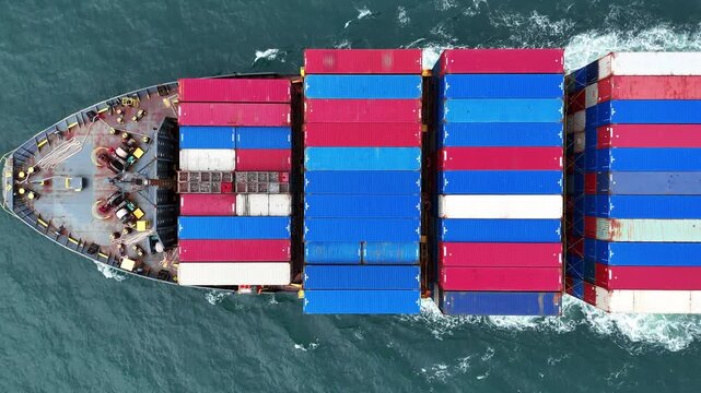 Aerial top view of cargo ship with contrail in the ocean sea ship carrying container and running from container international port smart freight shipping by ship service