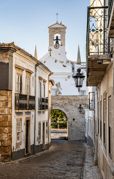 Rua do Municipio in Faro Old Town, leading toward the Arco da Vila, the monumental neoclassical gateway to the historic walled city, Algarve, Portugal