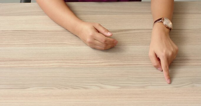 Close up of people talking to the camera, hands resting on wooden table, person wearing watch, waiti