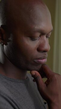 African American man portrait with downcast eyes and fingers touching chin expressing intense analytical reasoning mental discipline and earnest problem solving