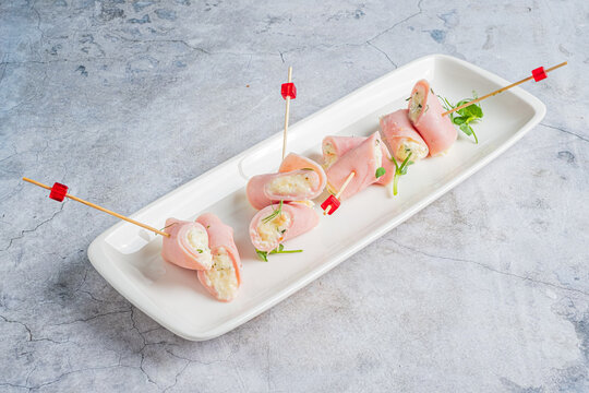 Delightful ham rolls filled with cheese and herbs served on a modern platter