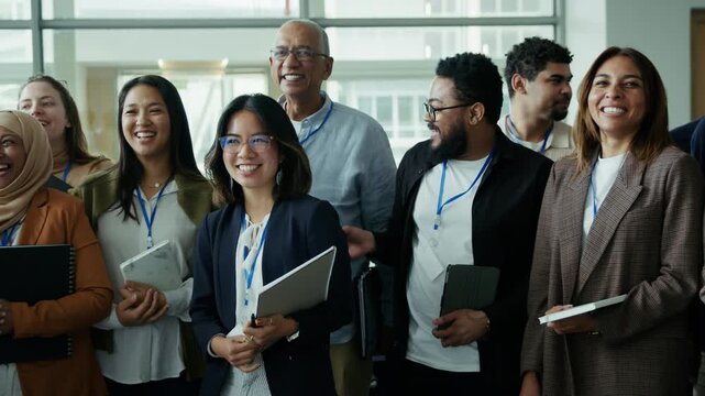 Professionals from diverse backgrounds share laughter at a business conference. Their expressions of happiness and collaboration highlight a positive and successful networking event.