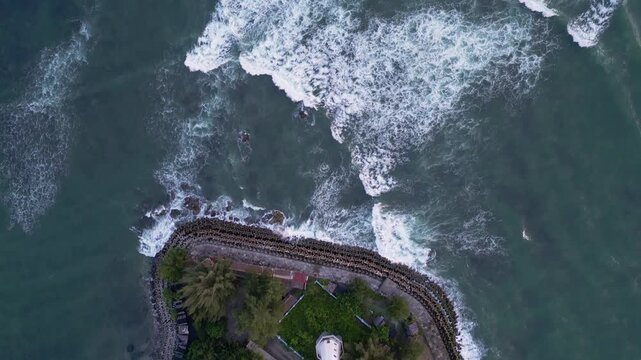 Meulaboh, Indonesia : Top down aerial drone footage of lighthouse in Meulaboh, coastal town in Aceh province of Sumatera in Indonesia with wave breaks into the coast