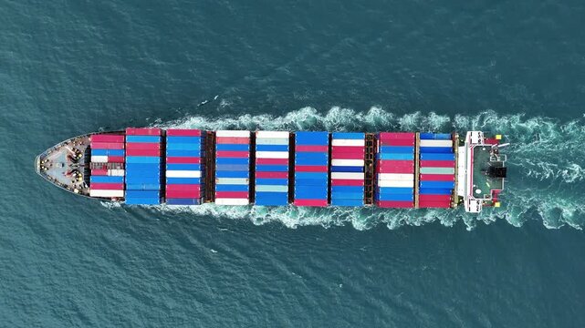 Aerial top view of cargo ship with contrail in the ocean sea ship carrying container and running from container international port smart freight shipping by ship service