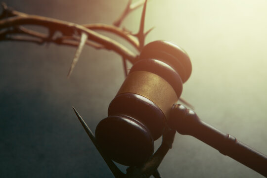Barbed wire crown of thorns and judge gavel on dark background