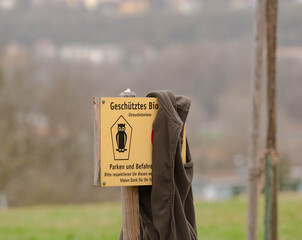 Forgotten Fleece Jacket Draped Over a German Nature Reserve Sign © Marrow83