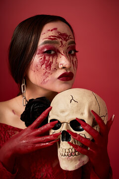 Asian dark queen with bloody allure brings Halloween horror to life with spooky skull