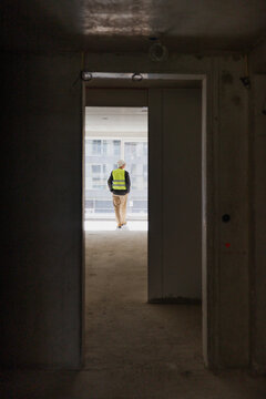a man seen through a doorway in a building under construction