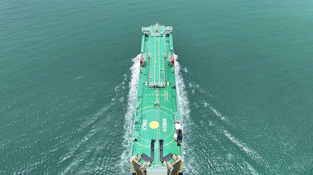 Large roll-on roll-off vehicle carrier ship sailing through the deep blue ocean. Global maritime logistics, international automotive trade, and heavy commercial freight transport
