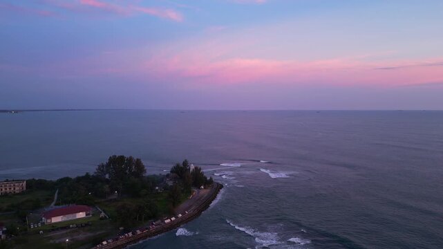 Meulaboh, Indonesia : Aerial drone footage of Meulaboh, coastal town in Aceh province of Sumatera in Indonesia. Taken with backward motion showing wave in the ocean and coastal road at sunset