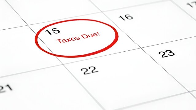 Calendar page with the 15th day circled in red and the text taxes due written next to it, symbolizing an important financial deadline
