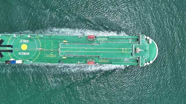 Large roll-on roll-off vehicle carrier ship sailing through the deep blue ocean. Global maritime logistics, international automotive trade, and heavy commercial freight transport