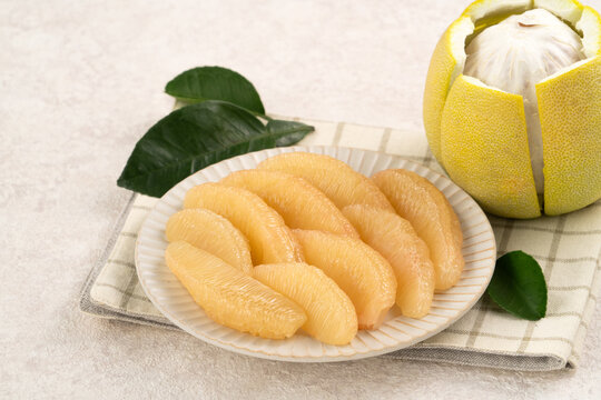 Fresh pomelo fruit with leaf on white table background.