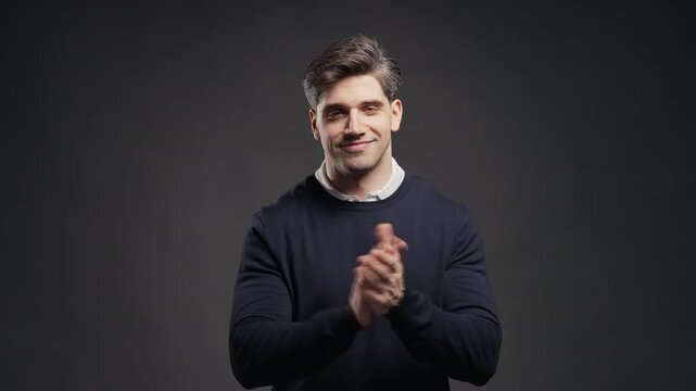 Smiling adult man applauds with open smile and active body language. Celebration, positive expression, congratulating, cheering, gratitude, bravo concept.