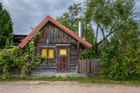 Rustic Wooden Cabin Beside an Apple Orchard Under Cloudy Skies