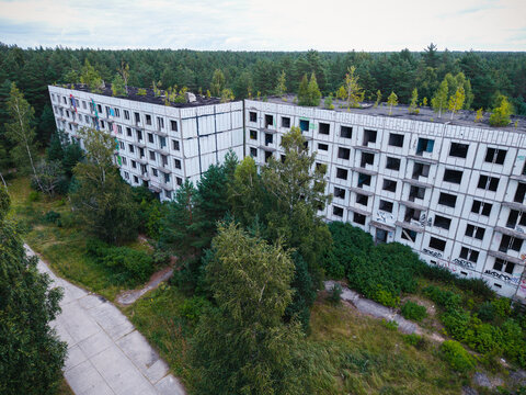 Aerial view of the abandoned Soviet military town of Irbene, featuring decaying concrete apartment blocks overgrown with trees and vegetation in Irbene, Ventspils Municipalit, Latvia.