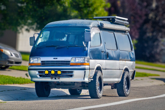 Calgary, AB, Canada - Sept 16, 2026: Vintage Toyota HiAce 4WD camper van with roof awning parked on a suburban street.