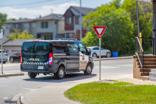 Calgary, AB, Canada - Sept 16, 2026: Calgary Police Service van driving through a residential neighborhood past a yield sign.