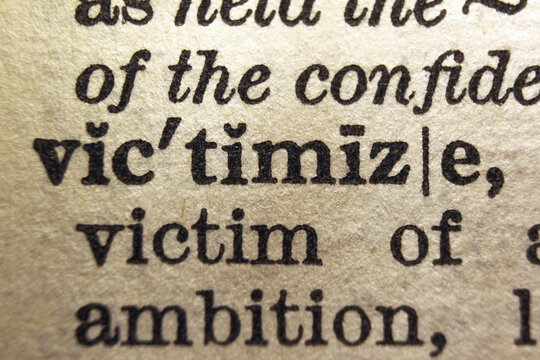 Word victimize printed on dictionary page, macro close 