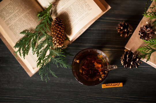 Cozy seasonal still life with hot tea, books and natural autumn decor