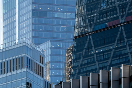 Layered glass office buildings in London England create a dense urban cityscape with reflective facades geometry and contemporary business architecture
