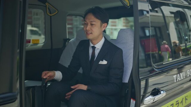 Businessman stepping out of a taxi and looking up at the city