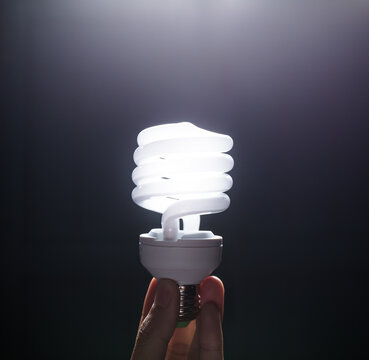 Energy saving fluorescent light bulb, isolated black background